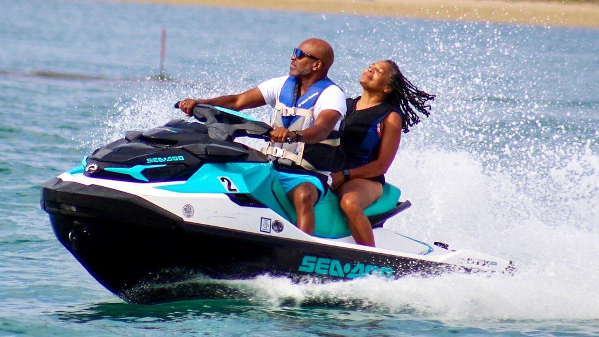 Two riders on a Jet Ski in clear water